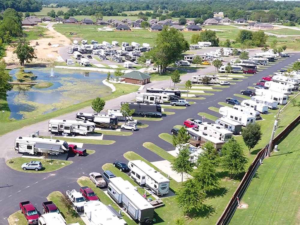 RVs parked along a paved road near pond at THE CREEKS GOLF & RV RESORT