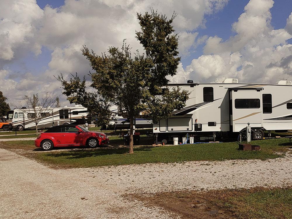 Fifth wheel and red car parked at site at ASHLAND/HUNTINGTON WEST KOA HOLIDAY