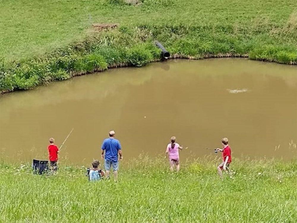 A family fishing in the pond at ASHLAND/HUNTINGTON WEST KOA HOLIDAY