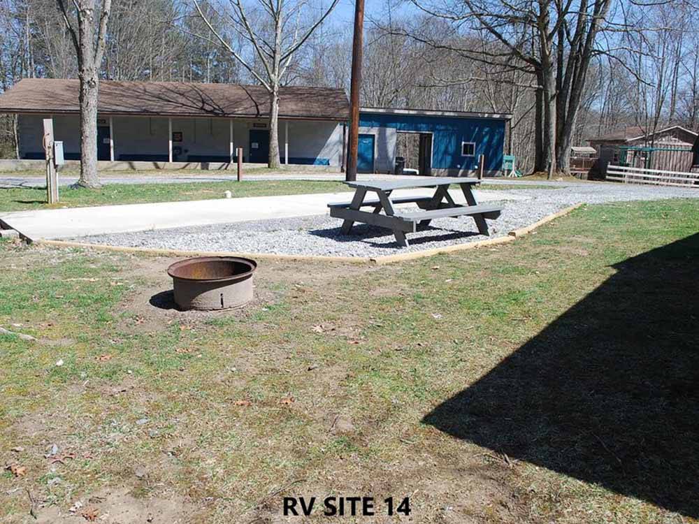 A picnic table and fire pit at RIFRAFTERS CAMPGROUND
