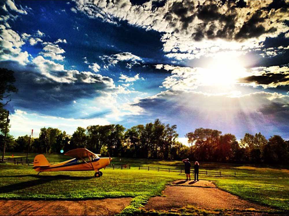 Couple standing near plane during beautiful day at ROBERT NEWLON RV PARK