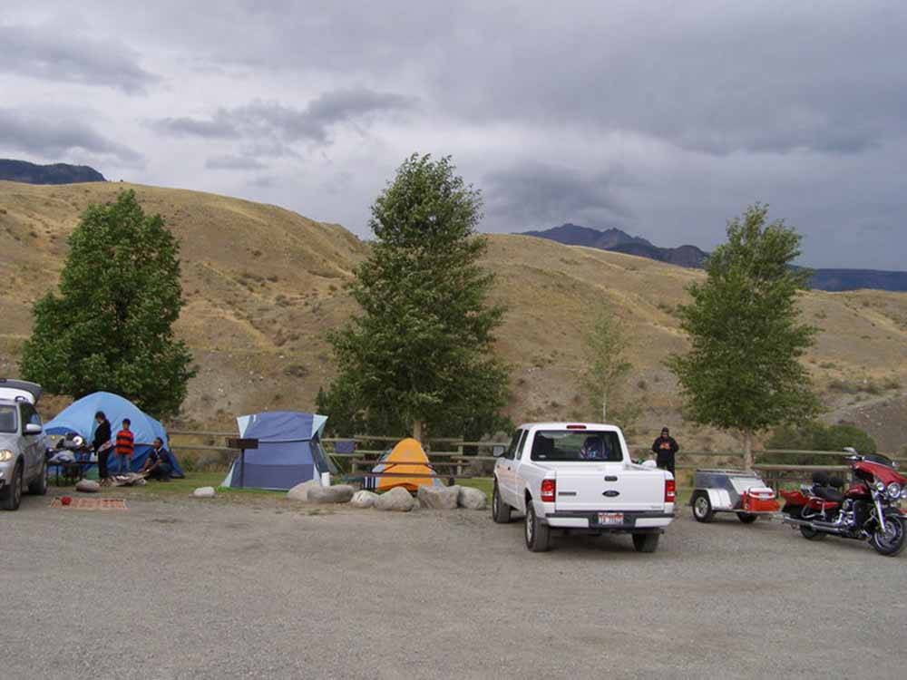 Vehicles parked near a hill at YELLOWSTONE RV PARK