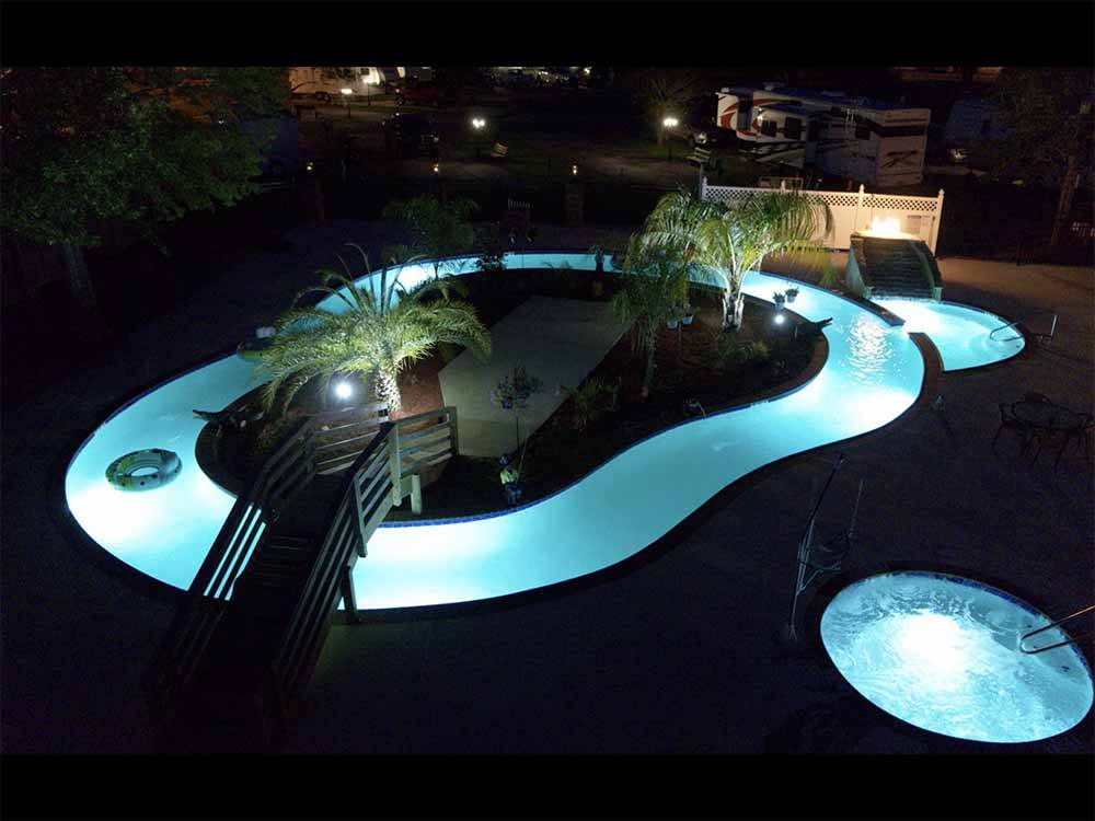An aerial view of the lazy river at night at TWELVE OAKS RV PARK