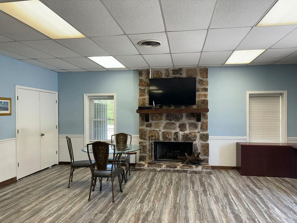 A TV above the fire place inside the communal room at CARSON VILLAGE MOBILE HOME & RV PARK