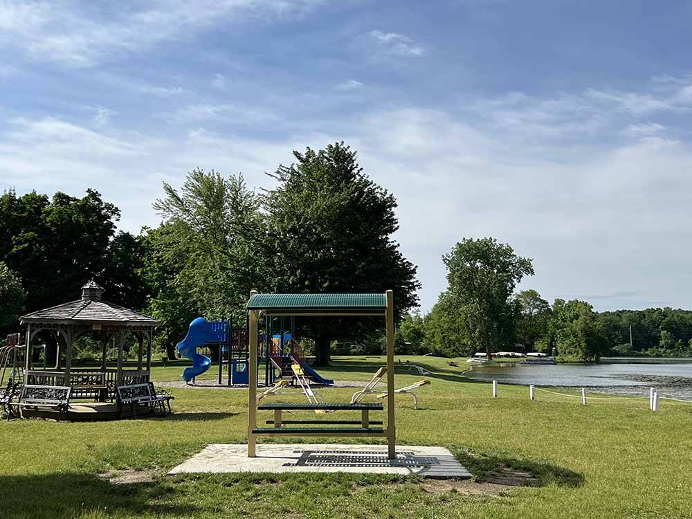 A swinging bench and playground equipment at SOMERSET BEACH CAMPGROUND & RETREAT CENTER