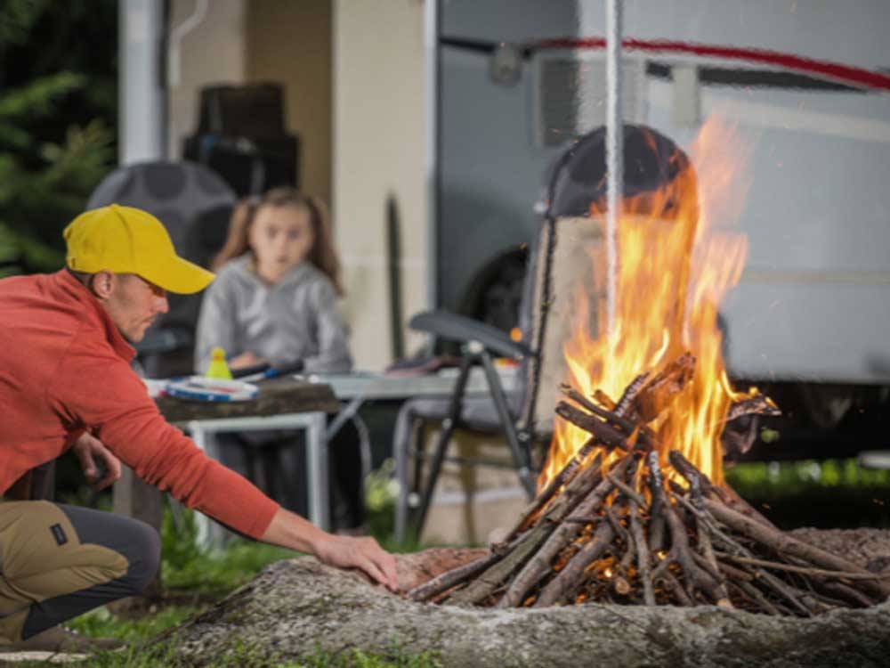Man setting up a bonfire at BALLARD'S CAMPGROUND