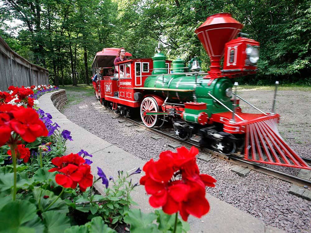 A green mini train takes a curve at WYLIE PARK CAMPGROUND & STORYBOOK LAND