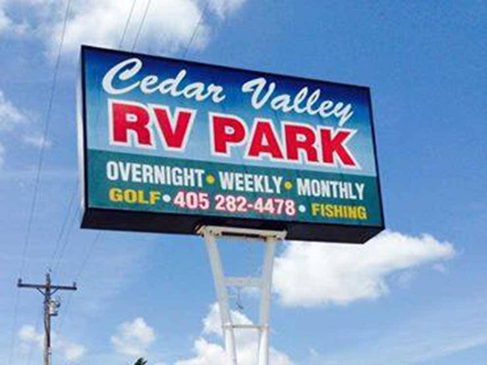 View of the tall park sign from below at CEDAR VALLEY RV PARK