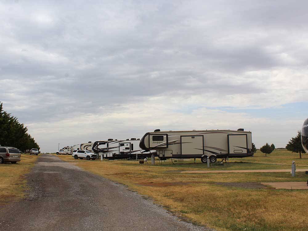 Row of Fifth-wheelers in grassy area at CEDAR VALLEY RV PARK