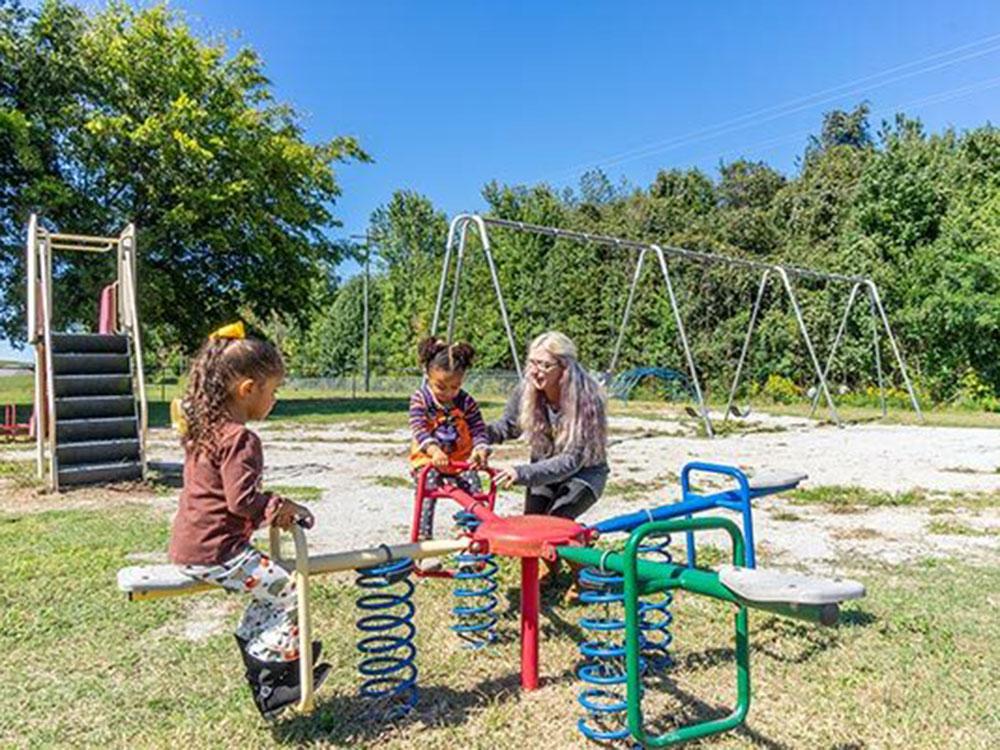 A mom with her kids at the playground at SWAN CREEK COMMUNITY (MHP)