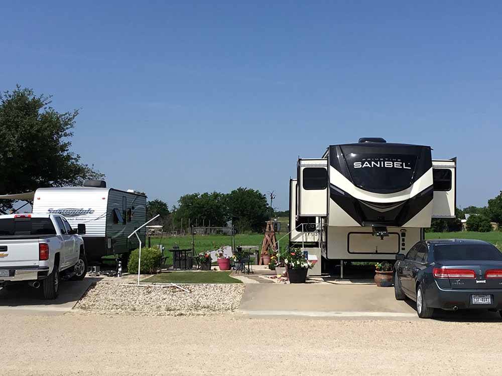 A fifth wheel trailer in a back in RV site at NEW LIFE RV PARK