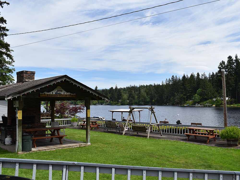 A pavilion and swing by the lake at RAINBOW RV RESORT