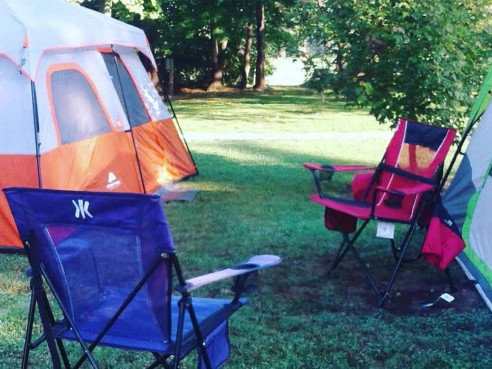 A couple of tents and camping chairs at MOUNTAIN PINES CAMPGROUND