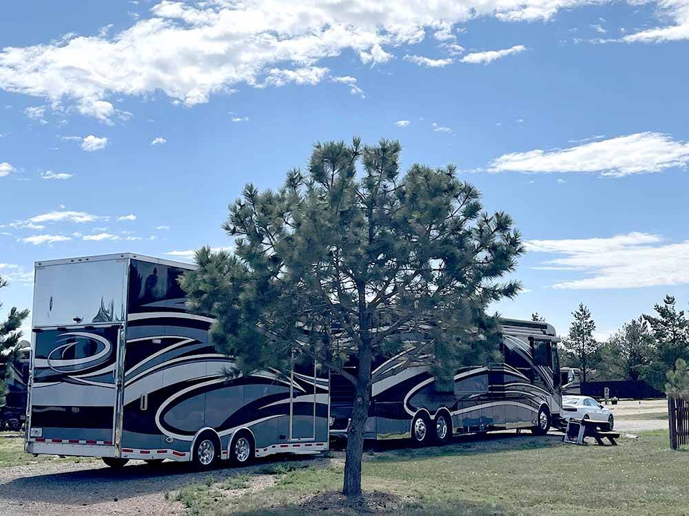 A large motorhome pulling a trailer in a pull thru site at NORTH PARK RV CAMPGROUND