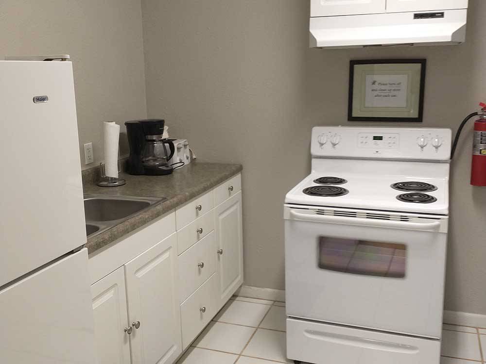 Small kitchen area with stove, coffee maker and fridge at NORTH PARK RV CAMPGROUND