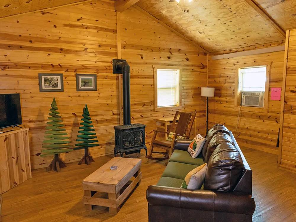 Cabin living room with wood stove at Custer's Gulch RV Park & Campground