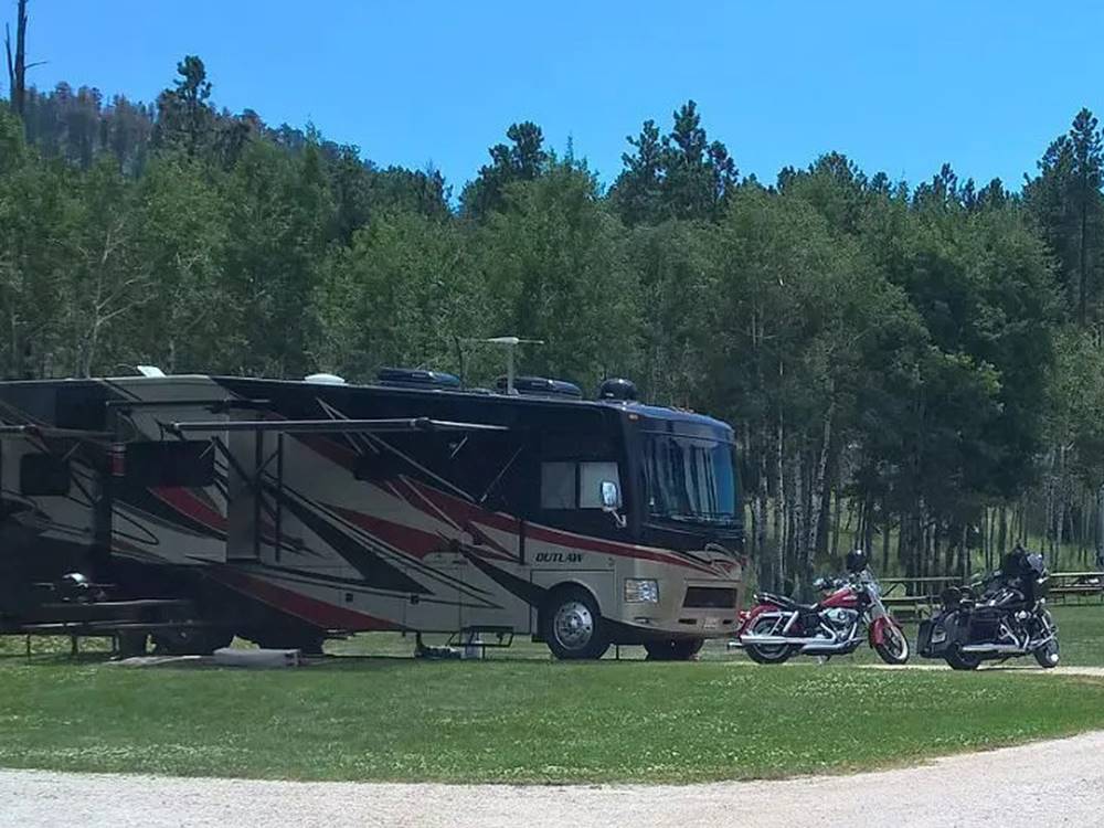 RVs and motorcycles at grass and gravel sites at Custer's Gulch RV Park & Campground