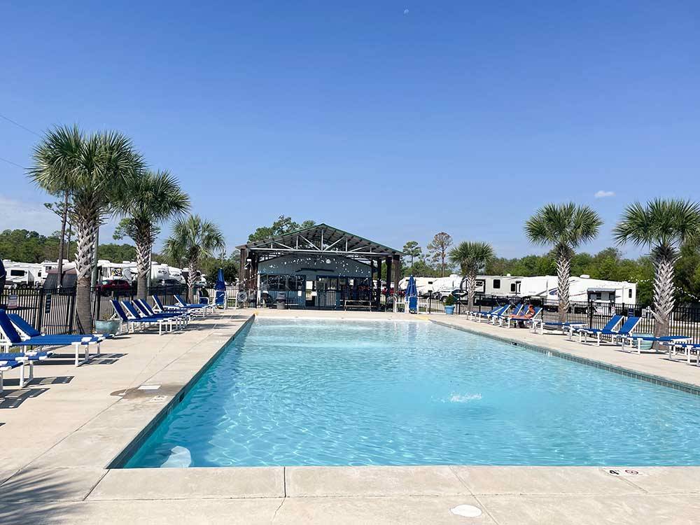 The swimming pool with lounge chairs at BAY PALMS RV RESORT
