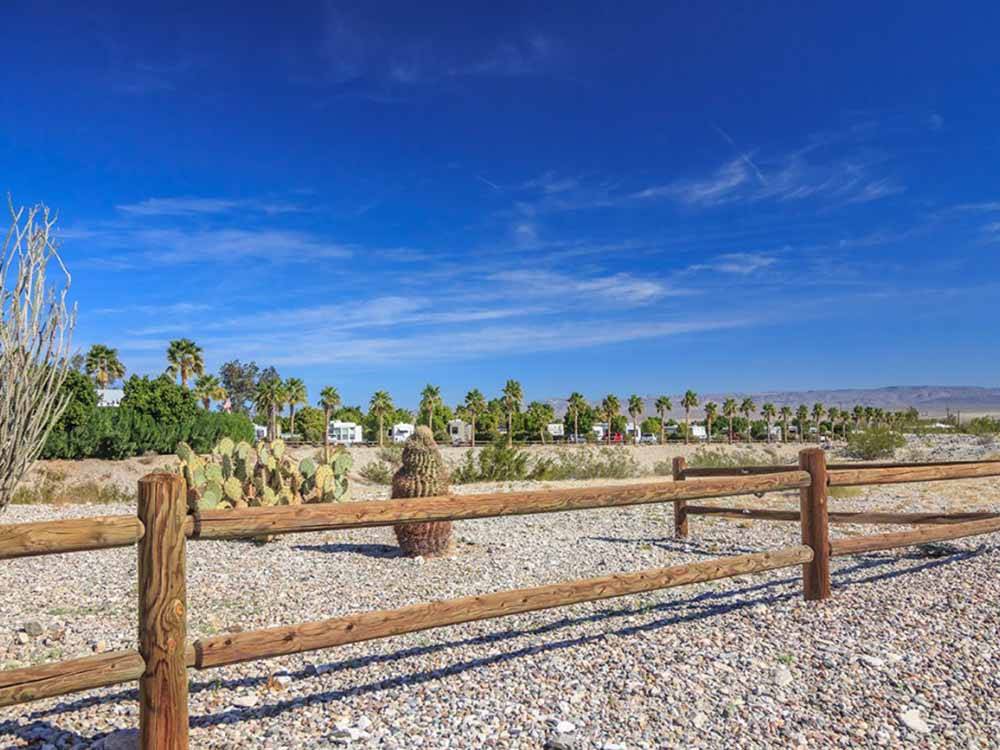 A wooden fence going thru the desert at DESERT VIEW RV RESORT