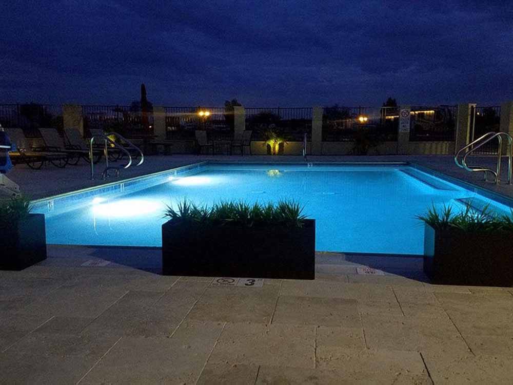 The swimming pool at night with the lights on at SONORAN DESERT RV PARK