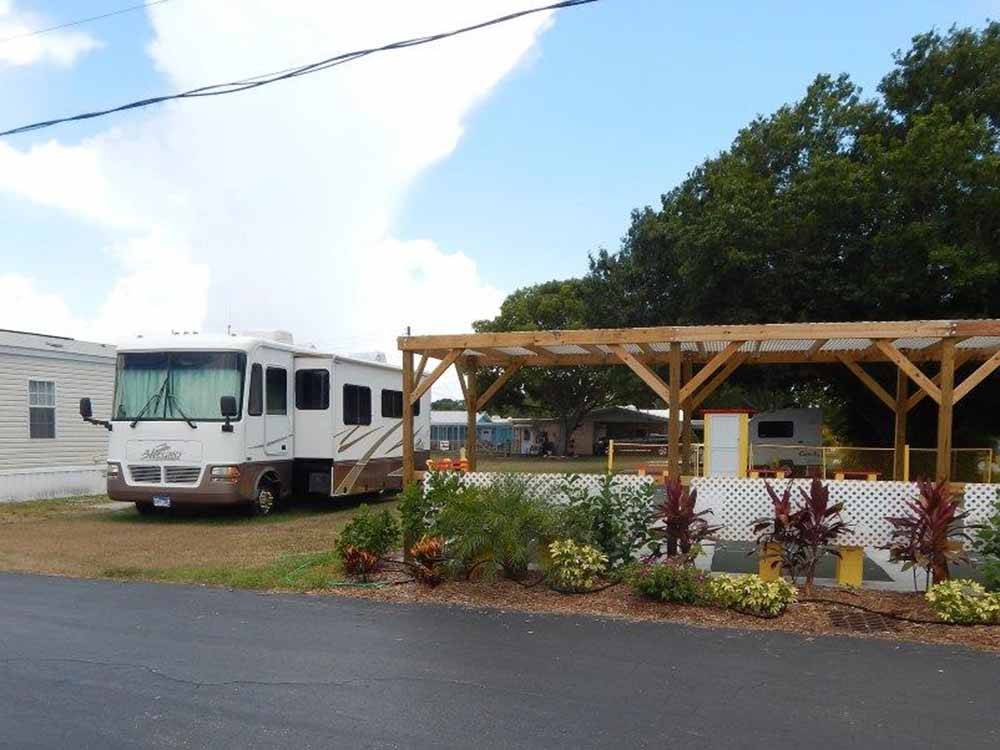 A motorhome next to a sitting area at TICE COURTS & RV PARK