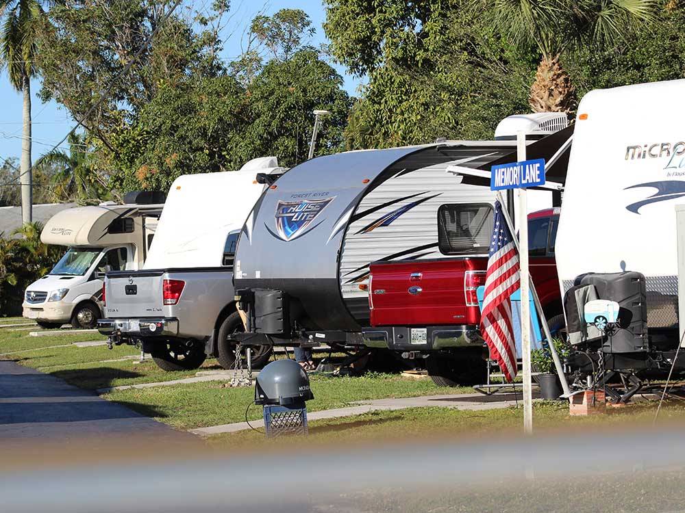 A row of RVs in back in spaces at TICE COURTS & RV PARK