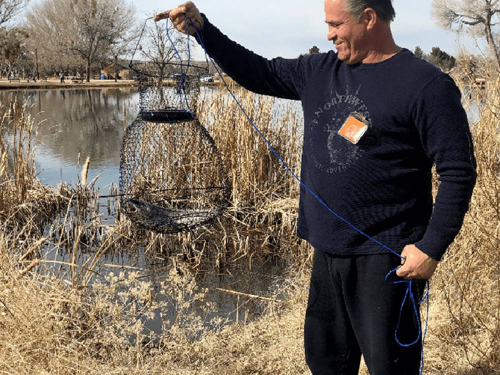 Man showing a fish in a net that he caught