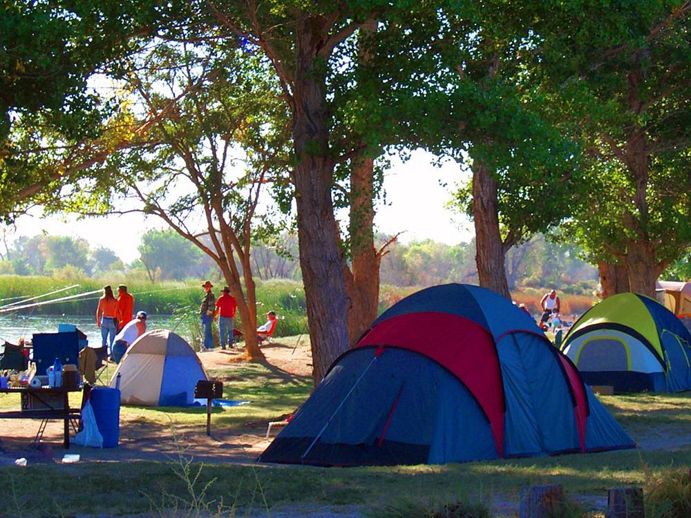 Camping tents, grills and lake in background