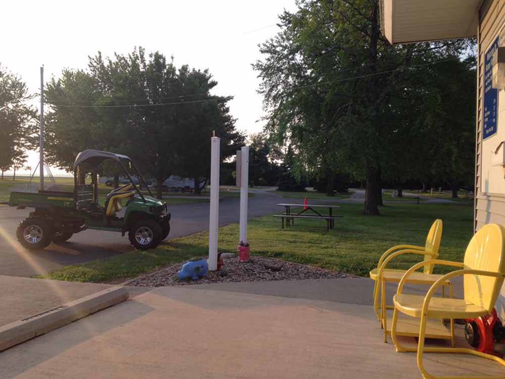 A couple of yellow chairs in front of the office at KAMP KOMFORT RV PARK & CAMPGROUND