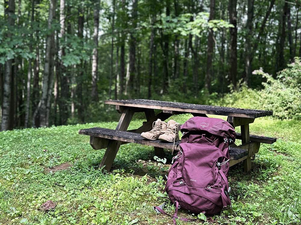 A backpack and shoes on a picnic table