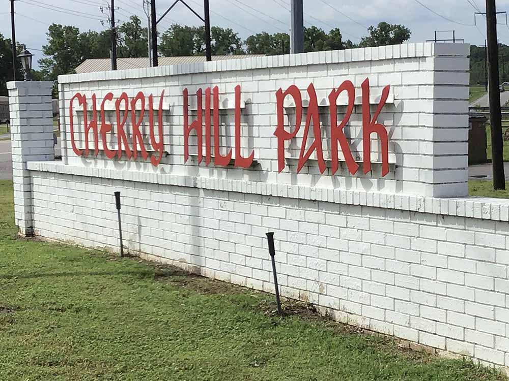 The metal park name sign on the brick wall at CHERRY HILL MH & RV COMMUNITY