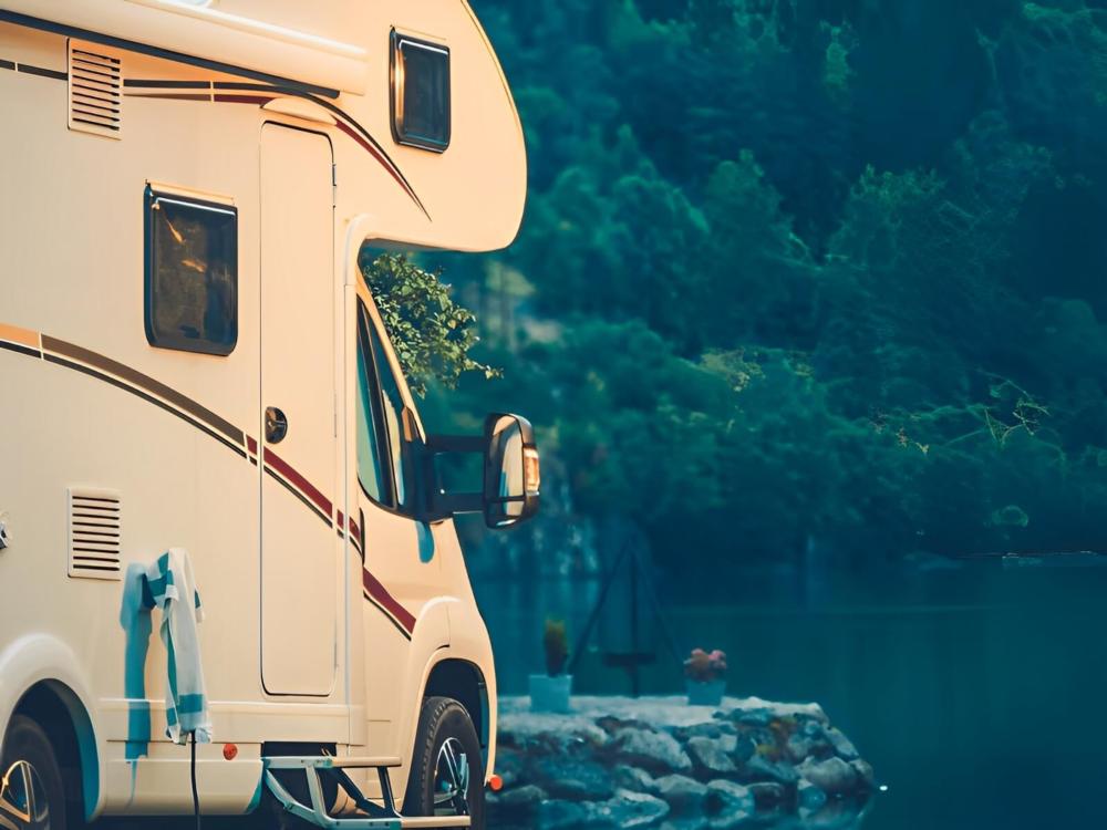 A Class C motorhome parked by the river