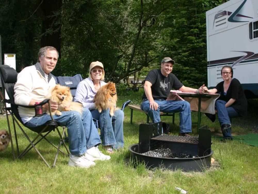 A group of people sitting around a fire ring at LOON LAKE LODGE & RV RESORT