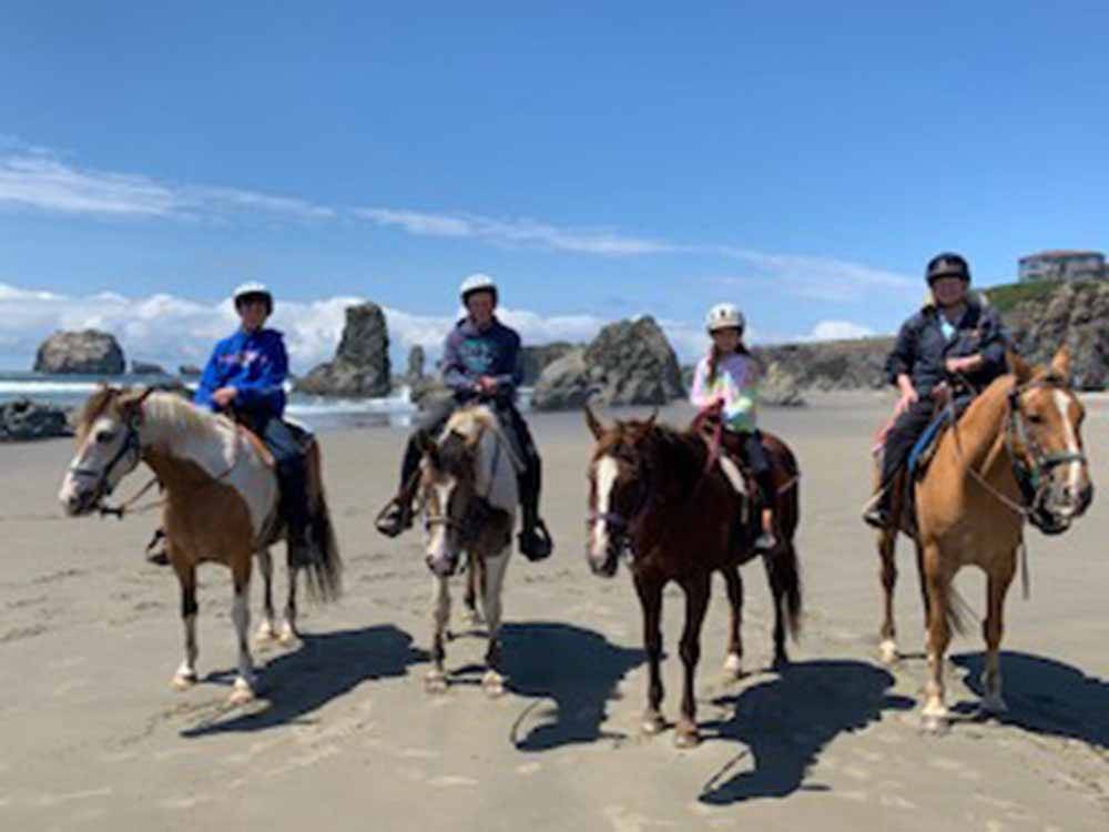 A group of people riding horses on the beach at BANDON BY THE SEA RV PARK