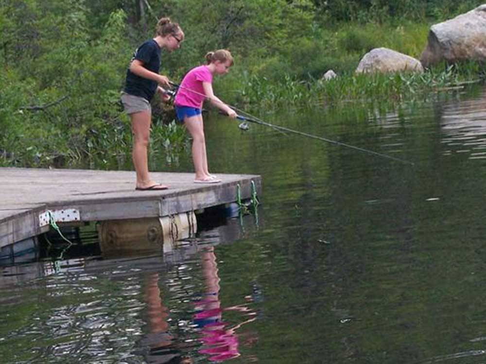 Girls fishing at MEREDITH WOODS 4 SEASON CAMPING AREA