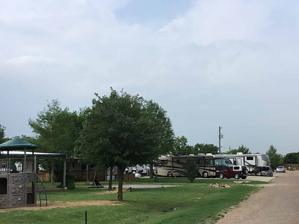 Play structures in foreground, RV sites in back at TEXAN RV RANCH