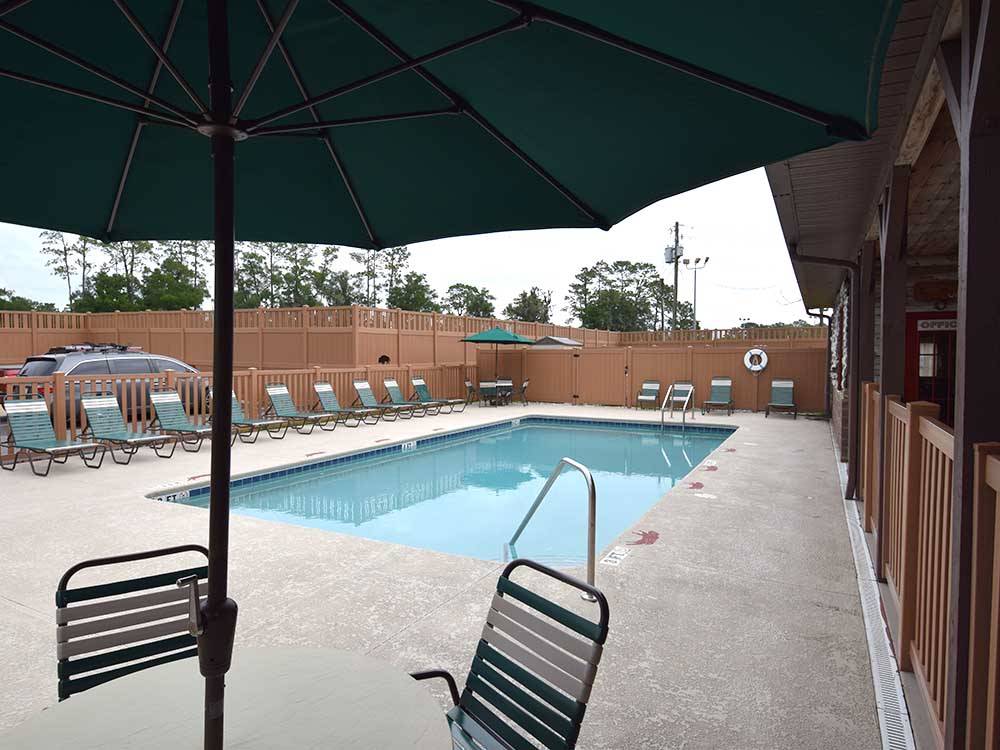Swimming pool with lounge chairs at WILD FRONTIER RV RESORT