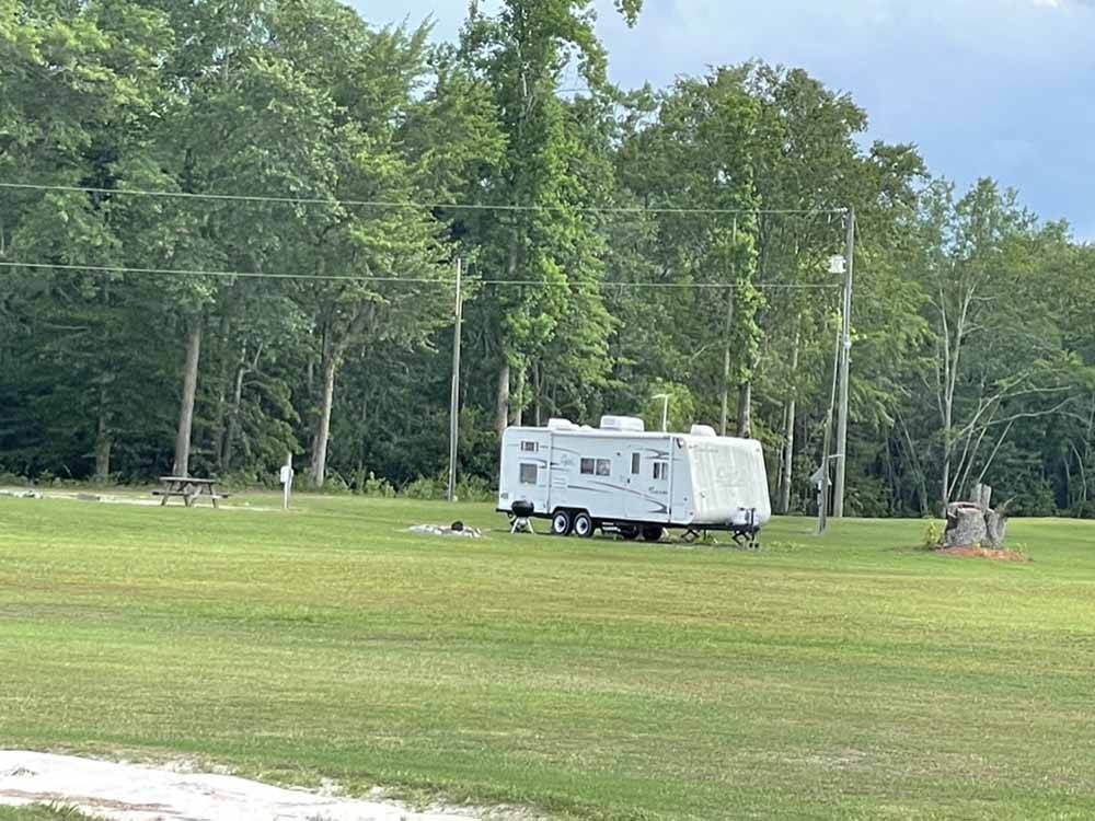 A travel trailer in a grassy field at ROCKY HOCK CAMPGROUND
