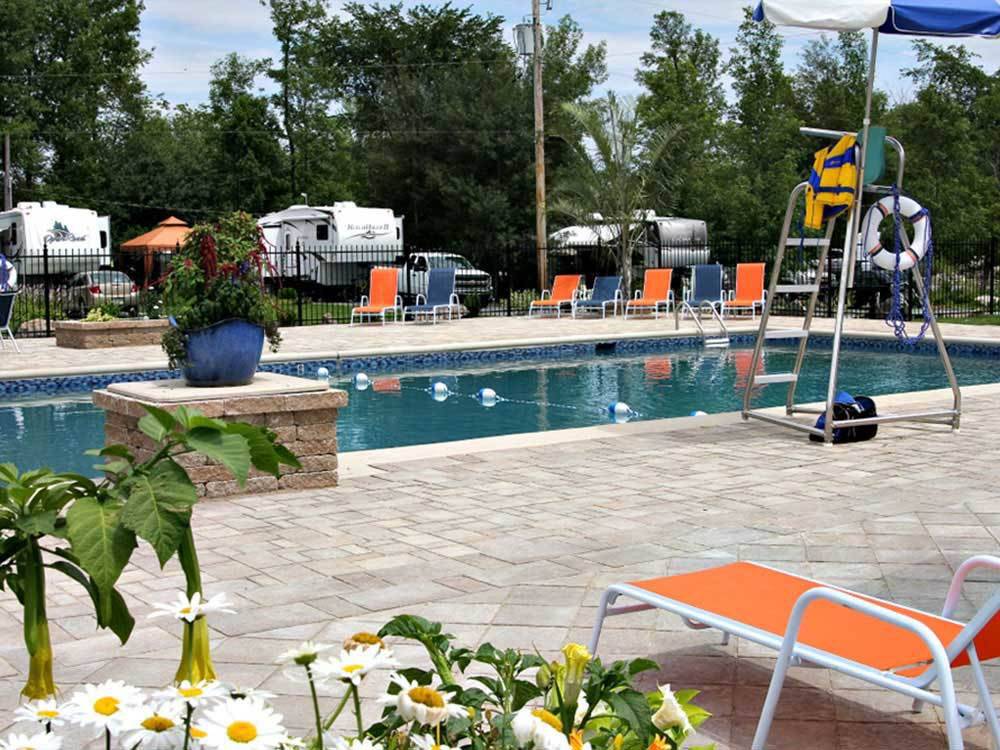 The swimming pool with orange and blue lounge chairs at CAMPING LA CLE DES CHAMPS RV RESORT