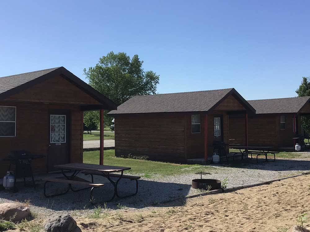 Wooden rental cabins with table and fire pit at BEYONDER GETAWAY AT LAZY ACRES