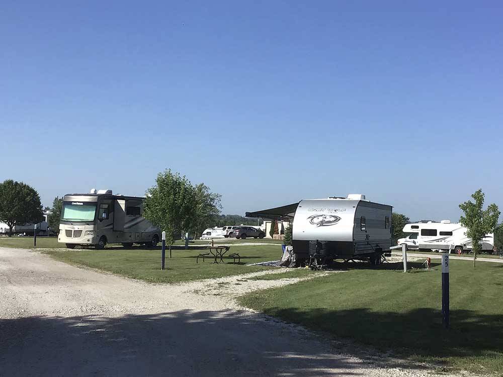 RV and travel trailer on grassy sites at BEYONDER GETAWAY AT LAZY ACRES