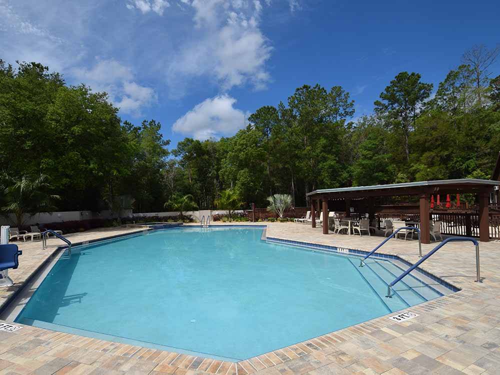 Large swimming pool with lounge chairs at WILLISTON CROSSINGS RV RESORT