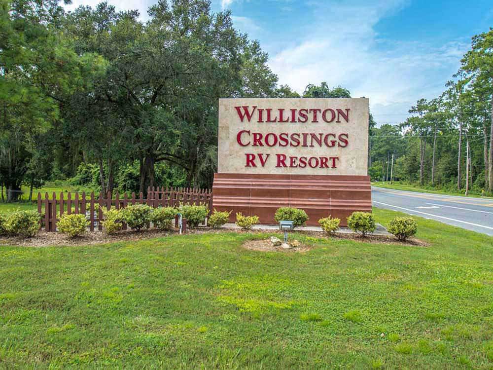 Large entrance sign with fence at WILLISTON CROSSINGS RV RESORT