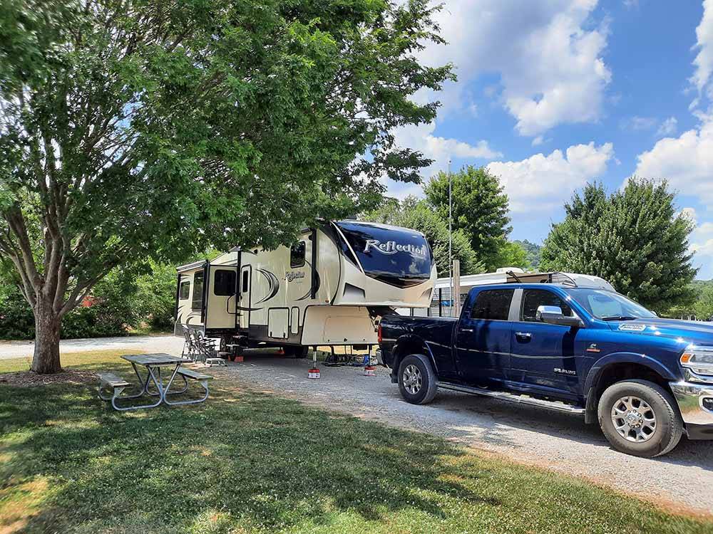 A fifth wheel trailer and truck in a pull thru site at CAVE COUNTRY RV CAMPGROUND
