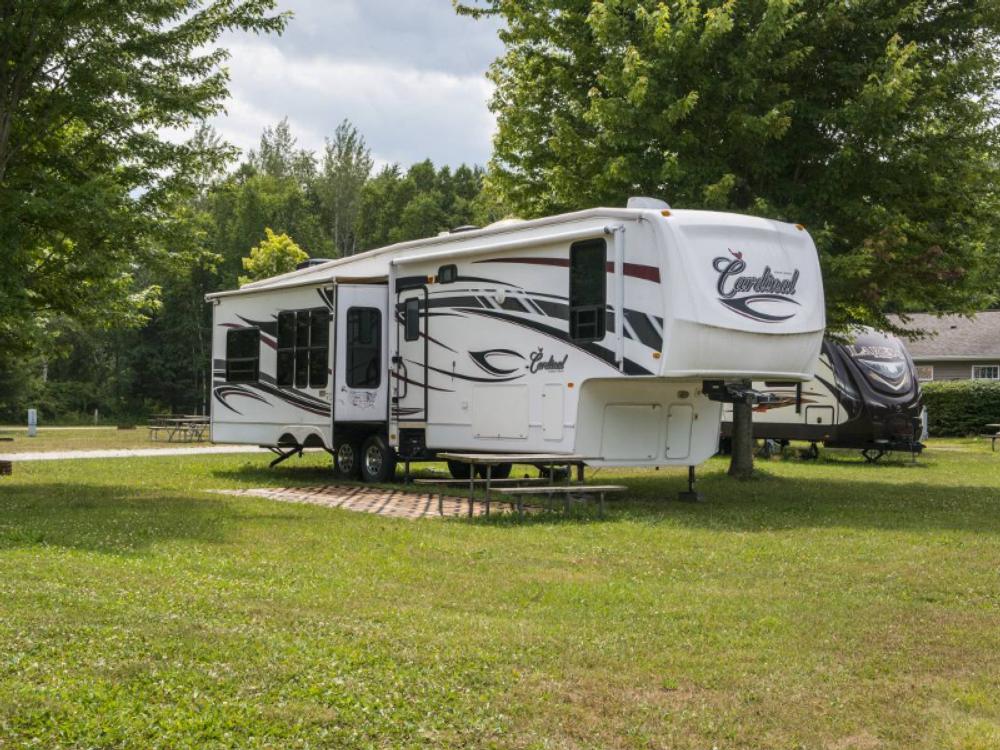 Fifth wheel RV in a grassy site at North Port Huron Jellystone Park