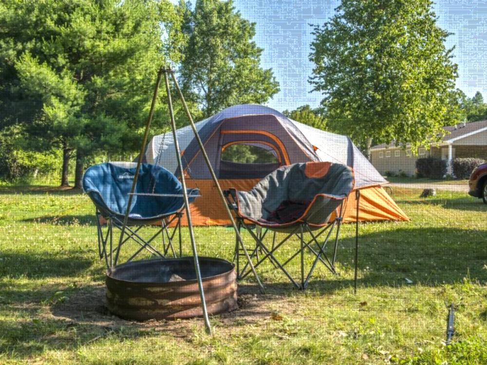 Tent next to fire pit at site North Port Huron Jellystone Park