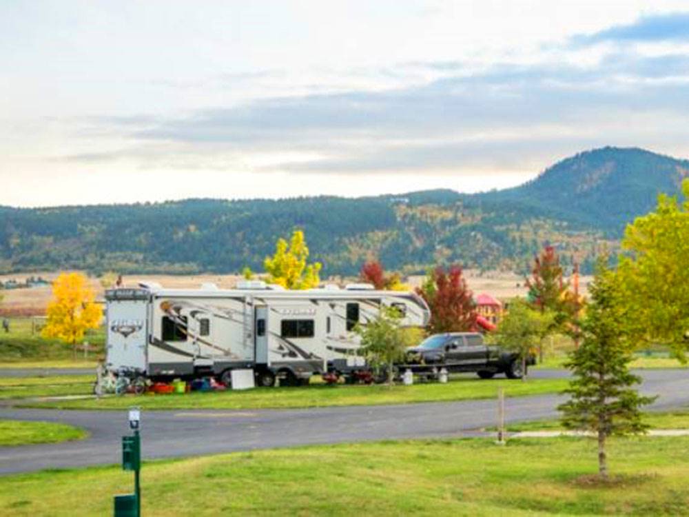 Fifth wheel trailer and black truck parked at site at ELKHORN RIDGE RV RESORT & CABINS