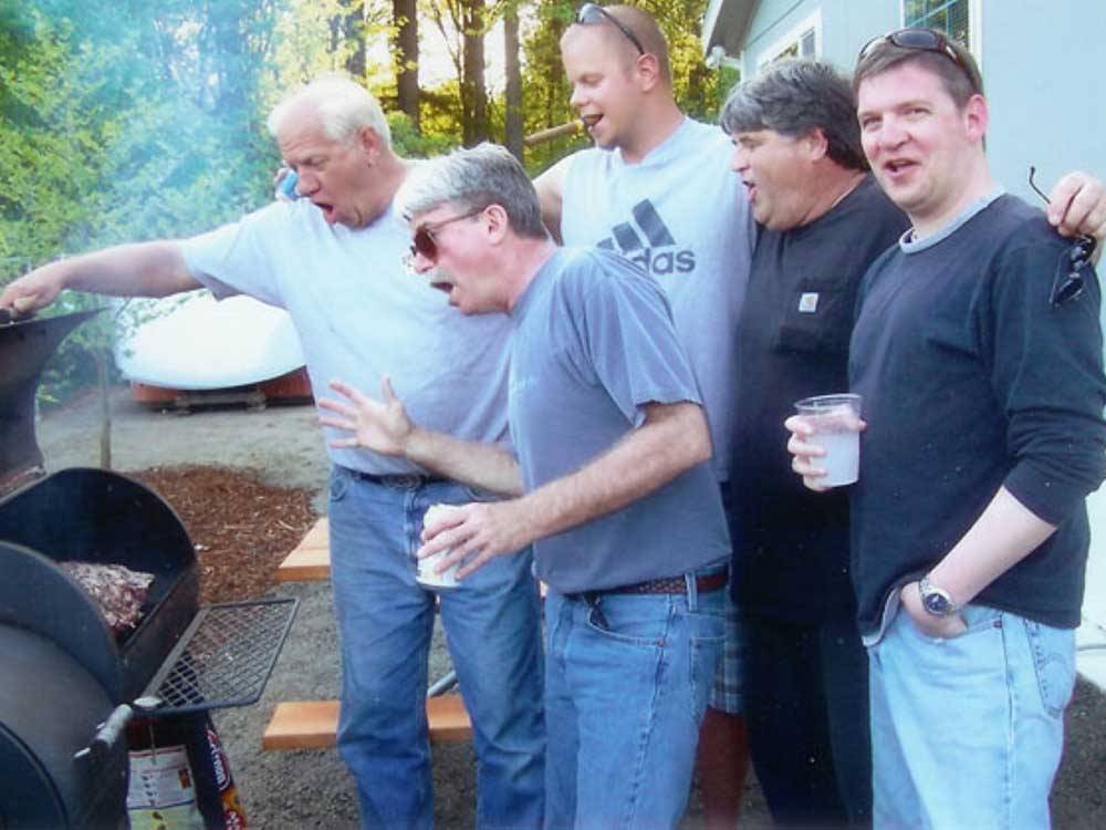 A bunch of men looking at a BBQ pit at TOUTLE RIVER RV RESORT