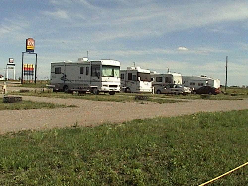 Row of motorhomes with sign in background at GOVERNORS' RV PARK CAMPGROUND
