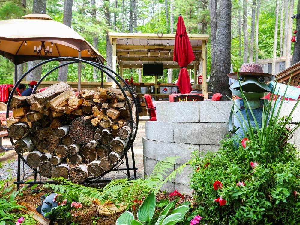 Patio area with a round log holder and frog statue at SANDY BEACH CAMPGROUND